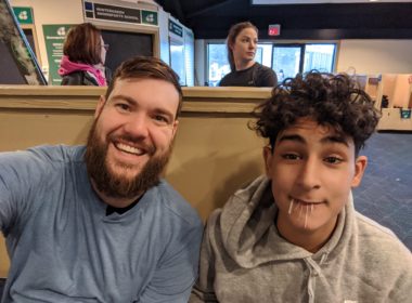 Big Brothers Big Sisters mentor and mentee sitting in restaurant booth smiling