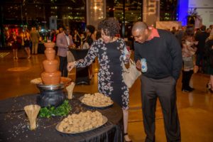 A couple admires and eats from a chocolate fountain