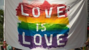LGBTQIA+ flag said "Love is Love"