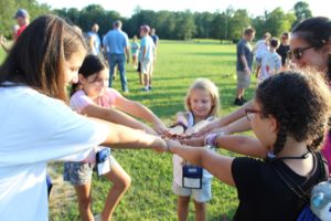 Five girls joining hands at Comfort Zone Camp