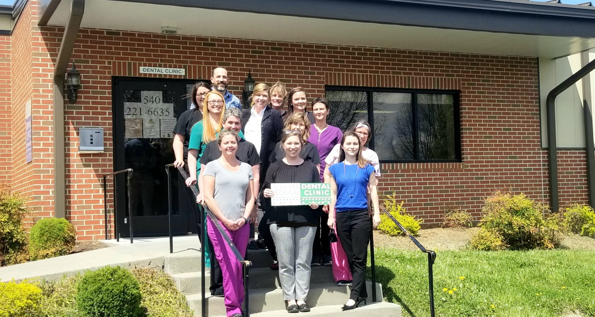 A group of people standing outside the Augusta Regional Dental Clinic