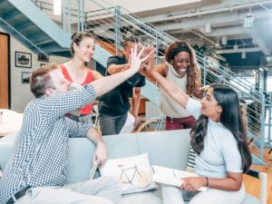 Diverse group of office professionals high-fiving each other