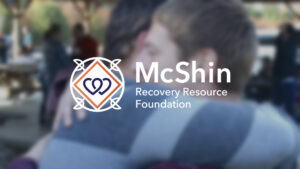 The McShin Foundation logo over two individuals hugging.