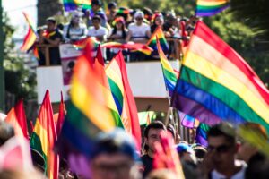 Gay pride parade with rainbow flags and float