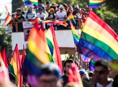 Gay pride parade with rainbow flags and float