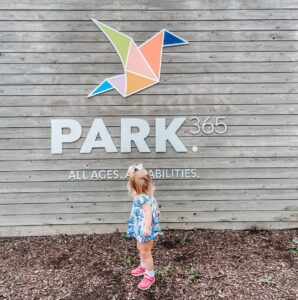 Little girl standing in front of PARK365 logo