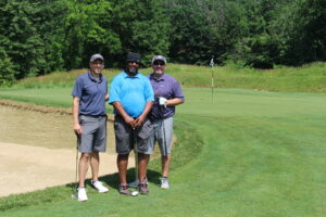Male golfers pose on the golf course