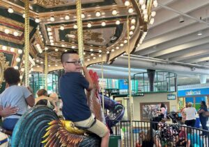 A child enjoys playing on a carousel