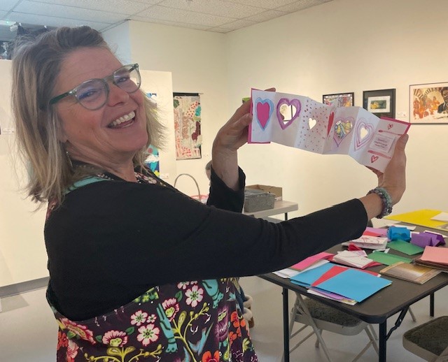 Susan Cary poses with a love book at Community Art Day on Feb. 3.